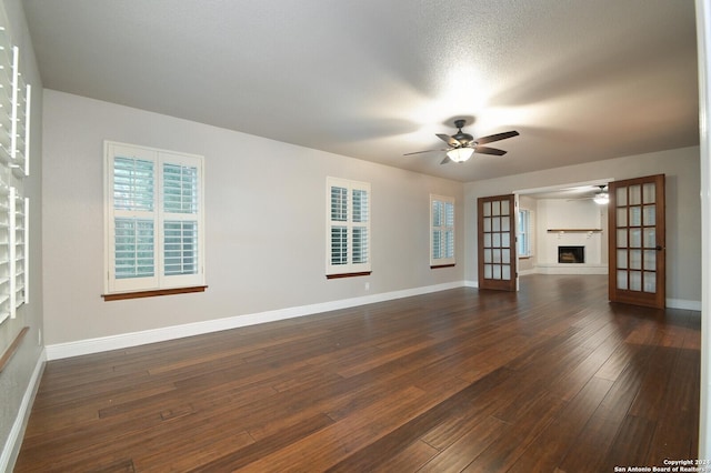 spare room with dark wood-type flooring, ceiling fan, french doors, and a textured ceiling