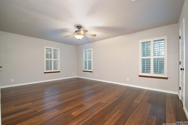 empty room featuring ceiling fan and dark hardwood / wood-style floors