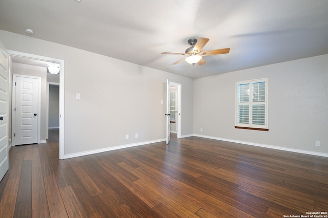 spare room featuring dark wood-type flooring and ceiling fan