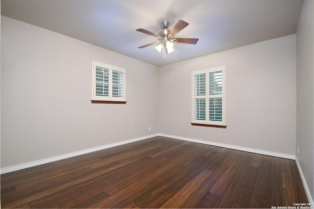 spare room with dark hardwood / wood-style floors and ceiling fan