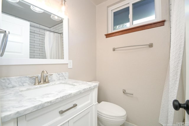 bathroom with walk in shower, vanity, and toilet