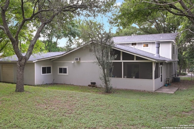 back of property with a sunroom, central air condition unit, and a lawn