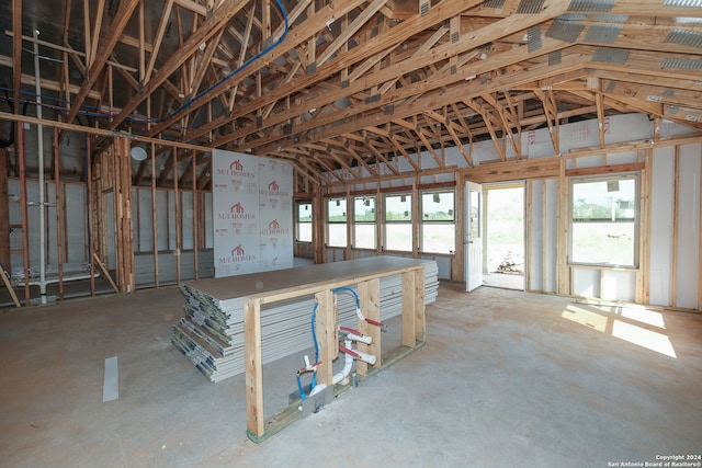 misc room with concrete flooring and lofted ceiling