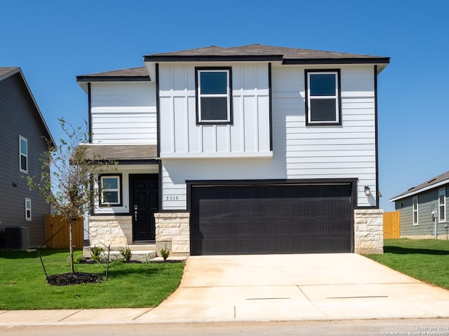 view of front of home with a garage, a front yard, and central AC unit