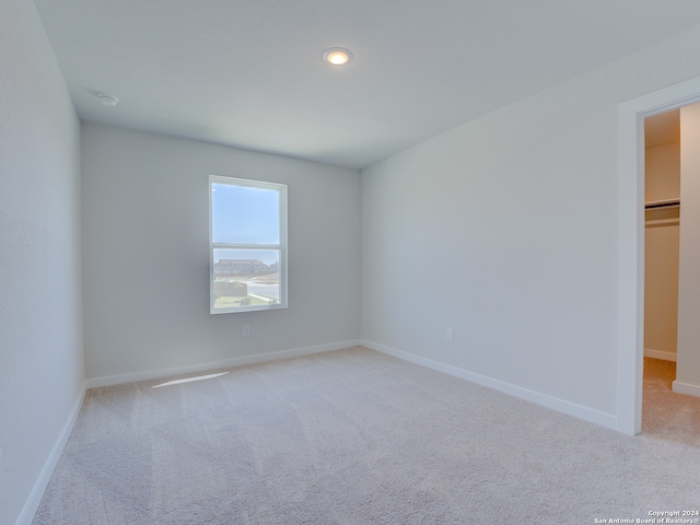 unfurnished room featuring light colored carpet