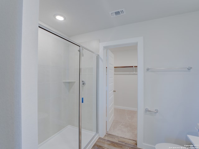 bathroom featuring hardwood / wood-style floors and an enclosed shower