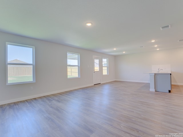 unfurnished room with sink and light wood-type flooring