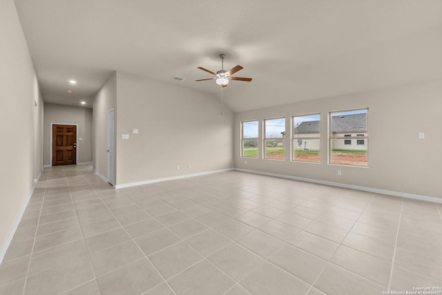 tiled spare room with vaulted ceiling and ceiling fan