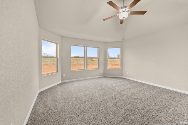 empty room with ceiling fan, vaulted ceiling, and carpet