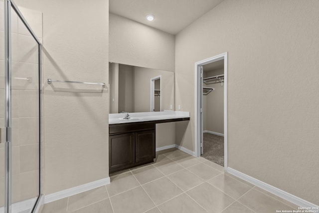 bathroom featuring vanity, walk in shower, and tile patterned flooring