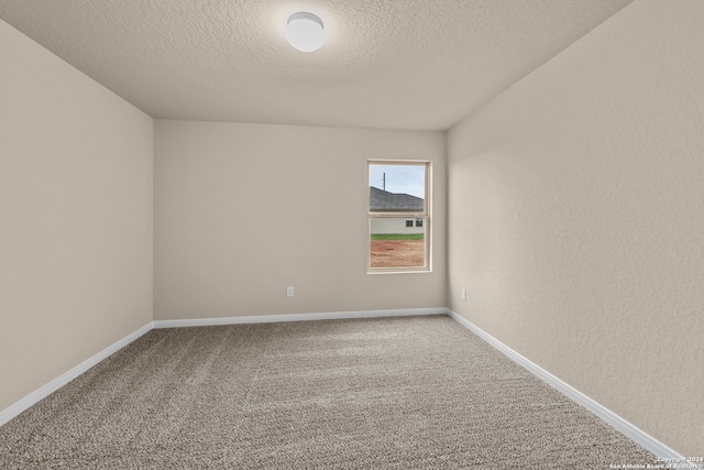 carpeted empty room with a textured ceiling