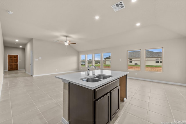 kitchen featuring ceiling fan, light tile patterned floors, sink, an island with sink, and lofted ceiling