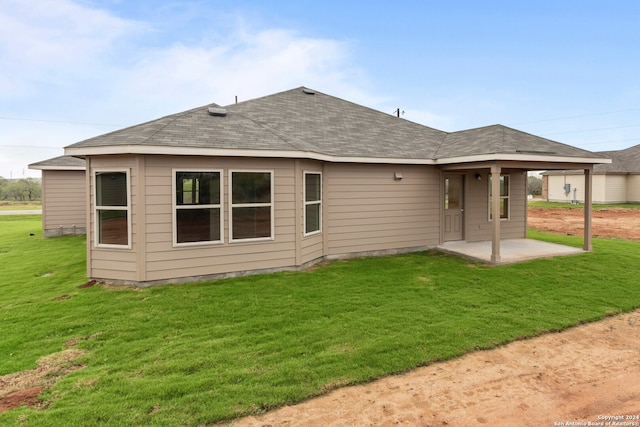 back of house featuring a patio area and a lawn