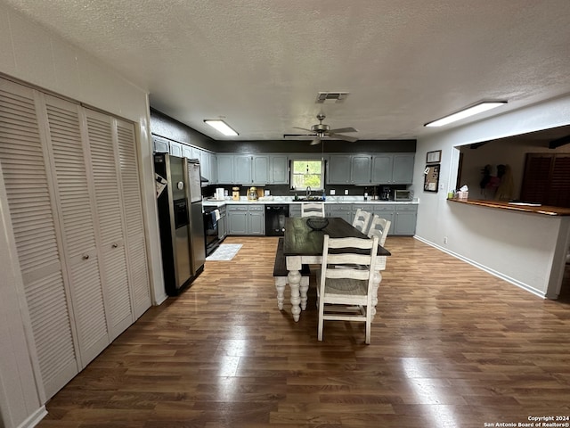 kitchen with gray cabinets, black appliances, hardwood / wood-style flooring, ceiling fan, and a textured ceiling