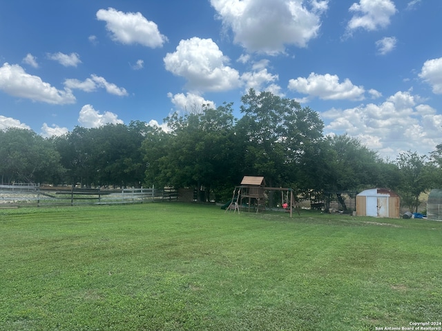 view of yard featuring a playground and a shed