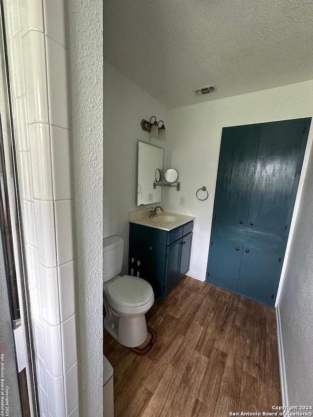 bathroom with vanity, a textured ceiling, toilet, and hardwood / wood-style floors