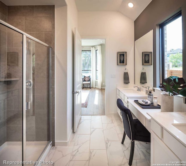 bathroom featuring vanity, a healthy amount of sunlight, walk in shower, and vaulted ceiling