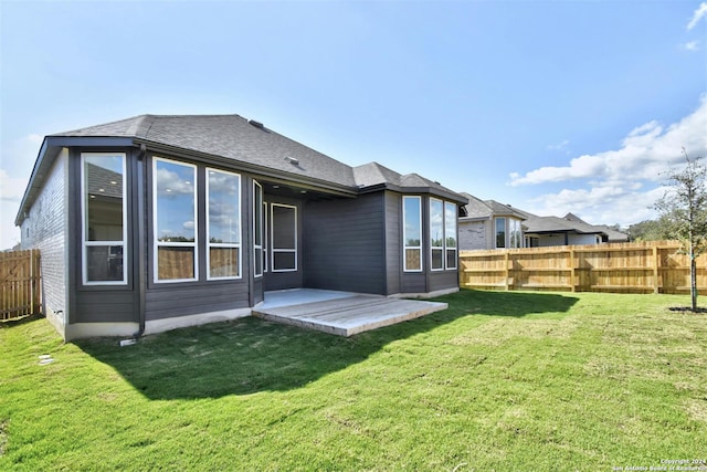 rear view of property featuring a lawn