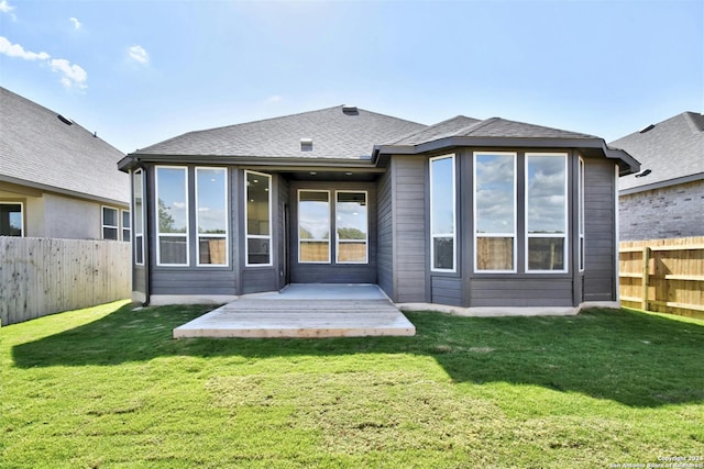 back of house with a sunroom and a lawn