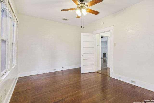 unfurnished room with ceiling fan and dark hardwood / wood-style flooring