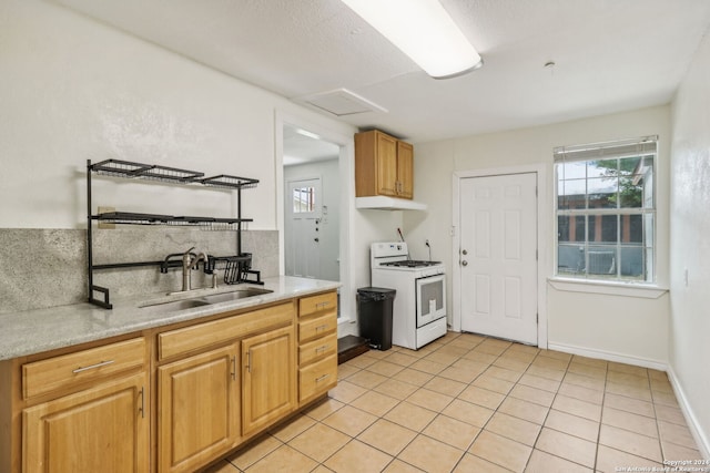 kitchen with sink, white range with gas stovetop, and light tile patterned floors