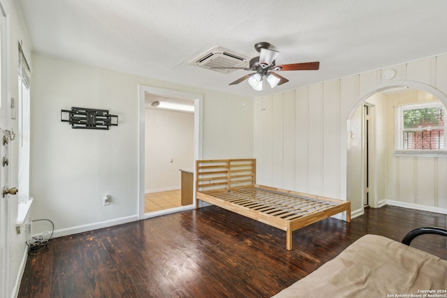 living area featuring ceiling fan, dark wood-type flooring, and a textured ceiling