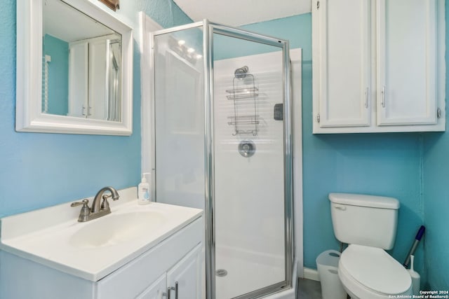 bathroom featuring vanity, toilet, and a shower with door