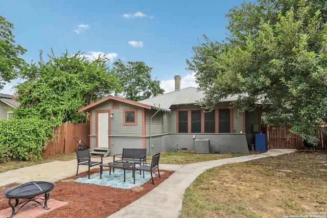 rear view of house with an outdoor fire pit, a patio area, and central air condition unit