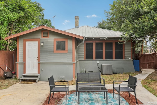 back of property with central AC unit and a patio area