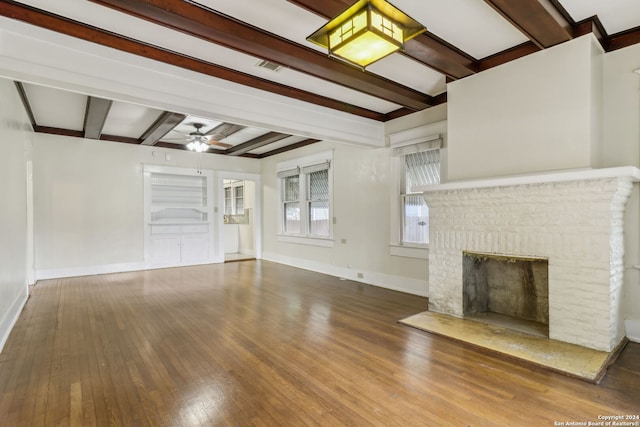 unfurnished living room with ceiling fan, hardwood / wood-style flooring, a fireplace, and beamed ceiling