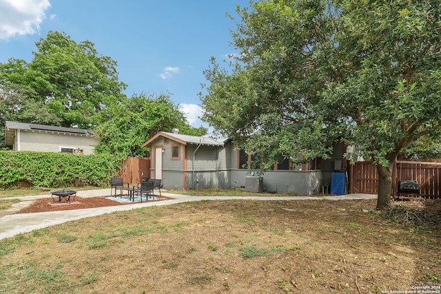 view of yard featuring a fire pit, a patio, and central air condition unit