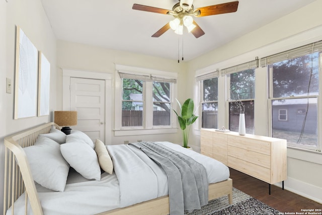 bedroom with dark hardwood / wood-style floors and ceiling fan