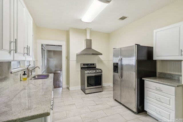 kitchen featuring sink, wall chimney range hood, appliances with stainless steel finishes, light stone countertops, and white cabinets