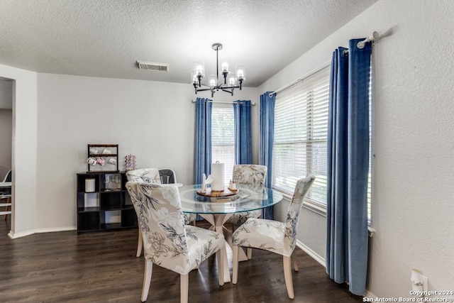 dining area featuring a chandelier, dark hardwood / wood-style floors, and a textured ceiling