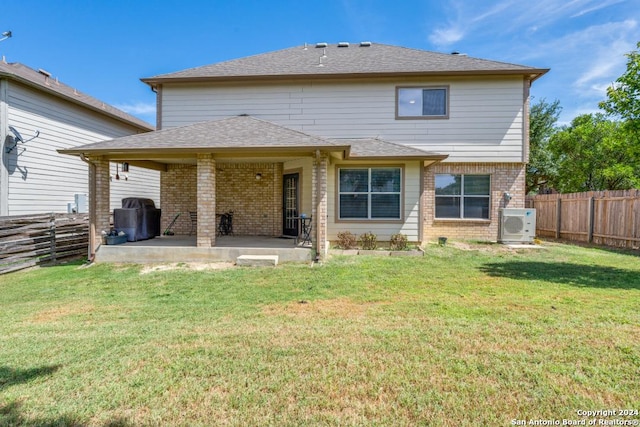 rear view of house with a patio area, ac unit, and a yard