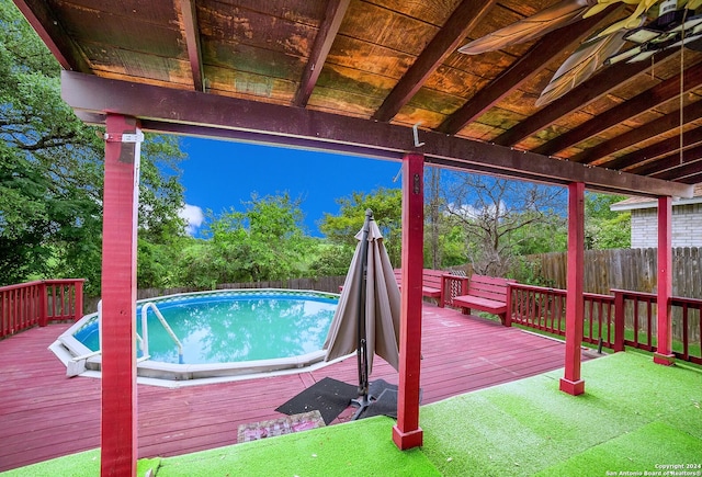 view of pool featuring a wooden deck and ceiling fan