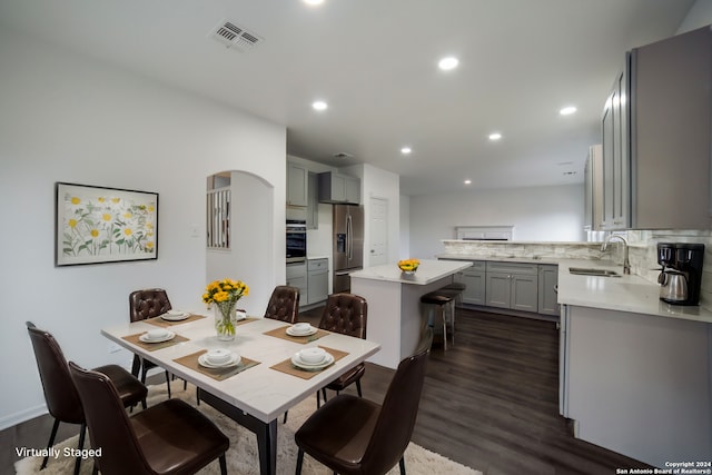 dining room featuring sink and dark wood-type flooring