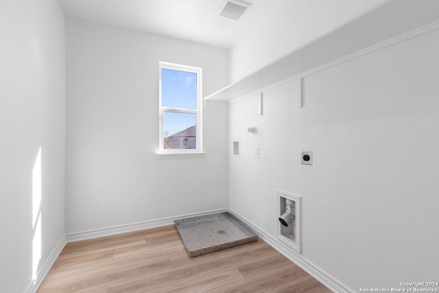 clothes washing area featuring electric dryer hookup, hookup for a gas dryer, light hardwood / wood-style floors, and washer hookup