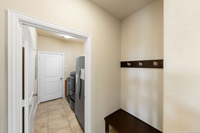 laundry area with light tile patterned floors and washer and dryer