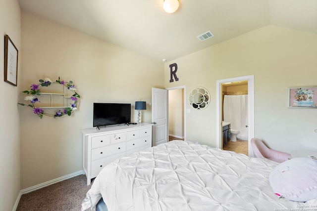 carpeted bedroom featuring lofted ceiling and ensuite bath