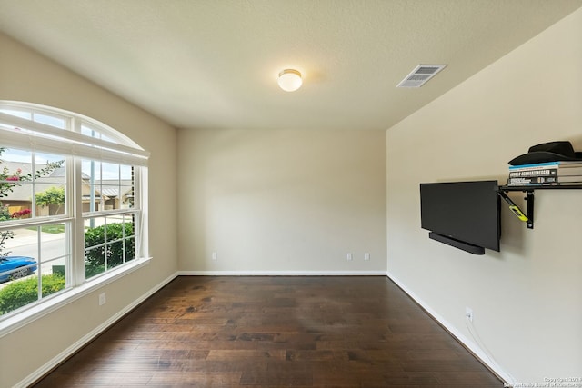 unfurnished room with plenty of natural light and dark hardwood / wood-style flooring