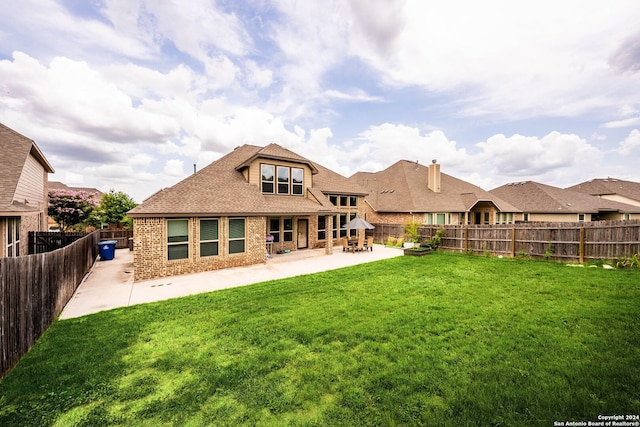 back of house with a yard and a patio area