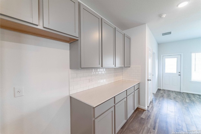kitchen with gray cabinetry, visible vents, light countertops, and tasteful backsplash