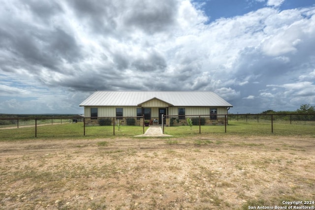 ranch-style house with a rural view and a front yard