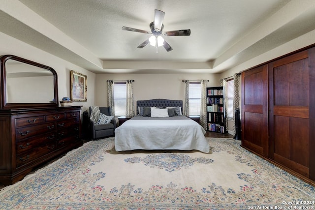 bedroom featuring ceiling fan and a tray ceiling