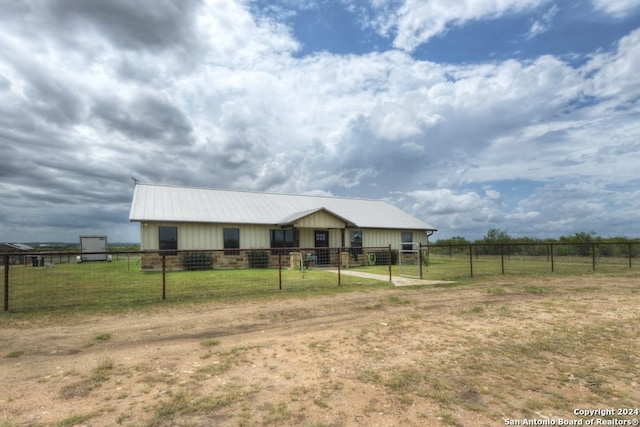 ranch-style house with a front yard and a rural view