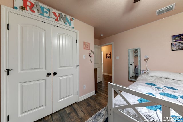 bedroom featuring dark wood-type flooring, a closet, and ceiling fan