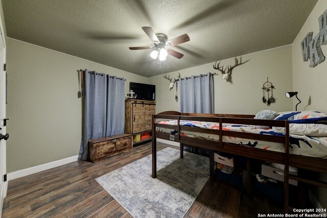 bedroom featuring dark hardwood / wood-style flooring, a textured ceiling, and ceiling fan