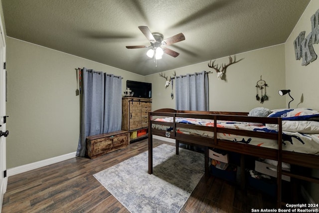 bedroom featuring a textured ceiling, dark hardwood / wood-style floors, and ceiling fan