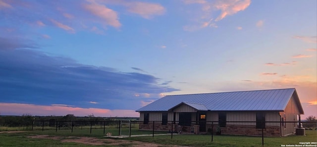 view of front of house featuring central air condition unit and a lawn